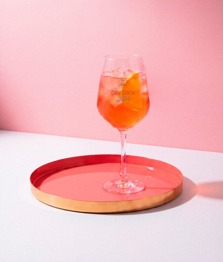 Copa de Dry Sack Spritz sobre un plato rosa