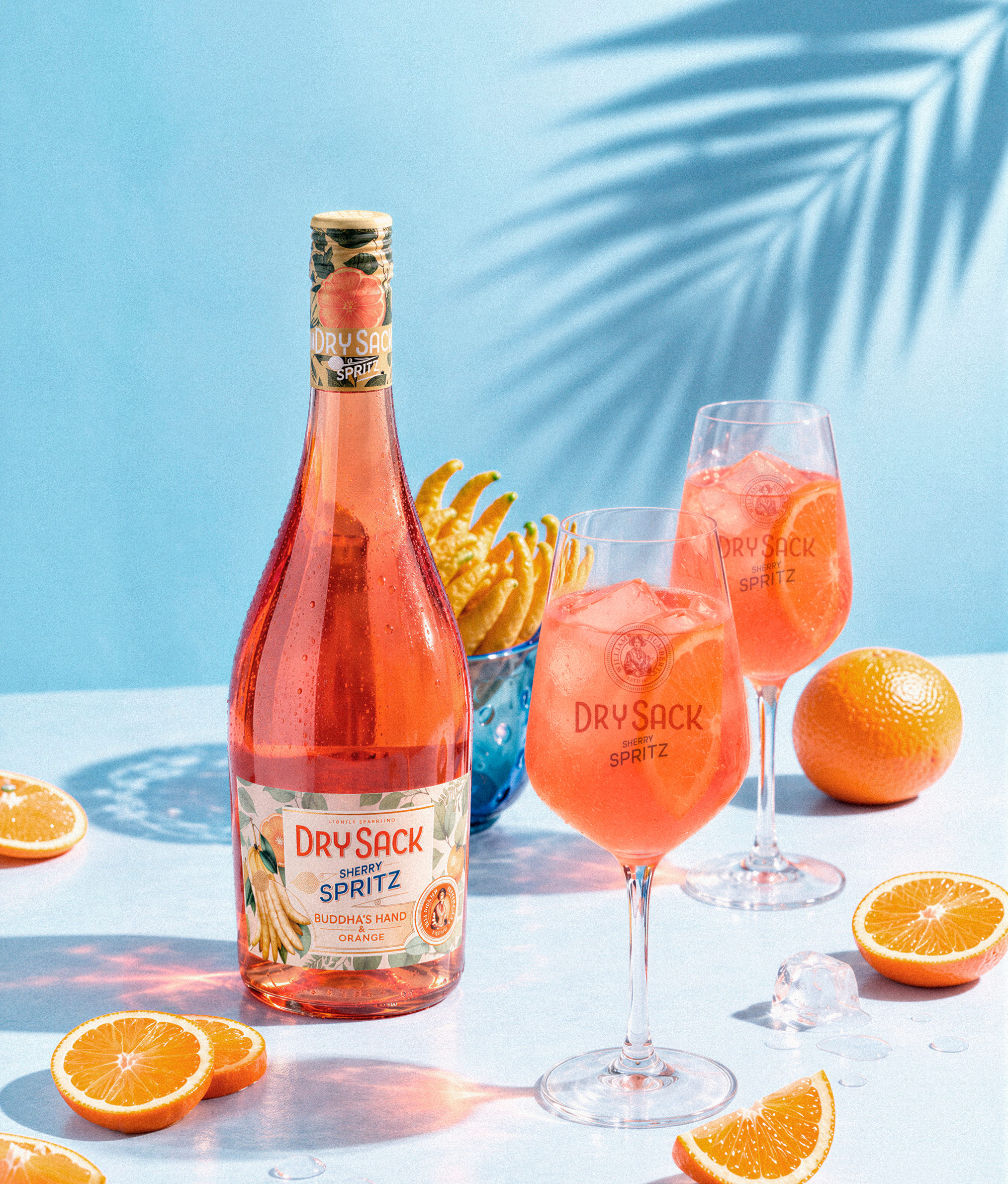 Botella de Dry Sack Spritz con dos copas y naranjas