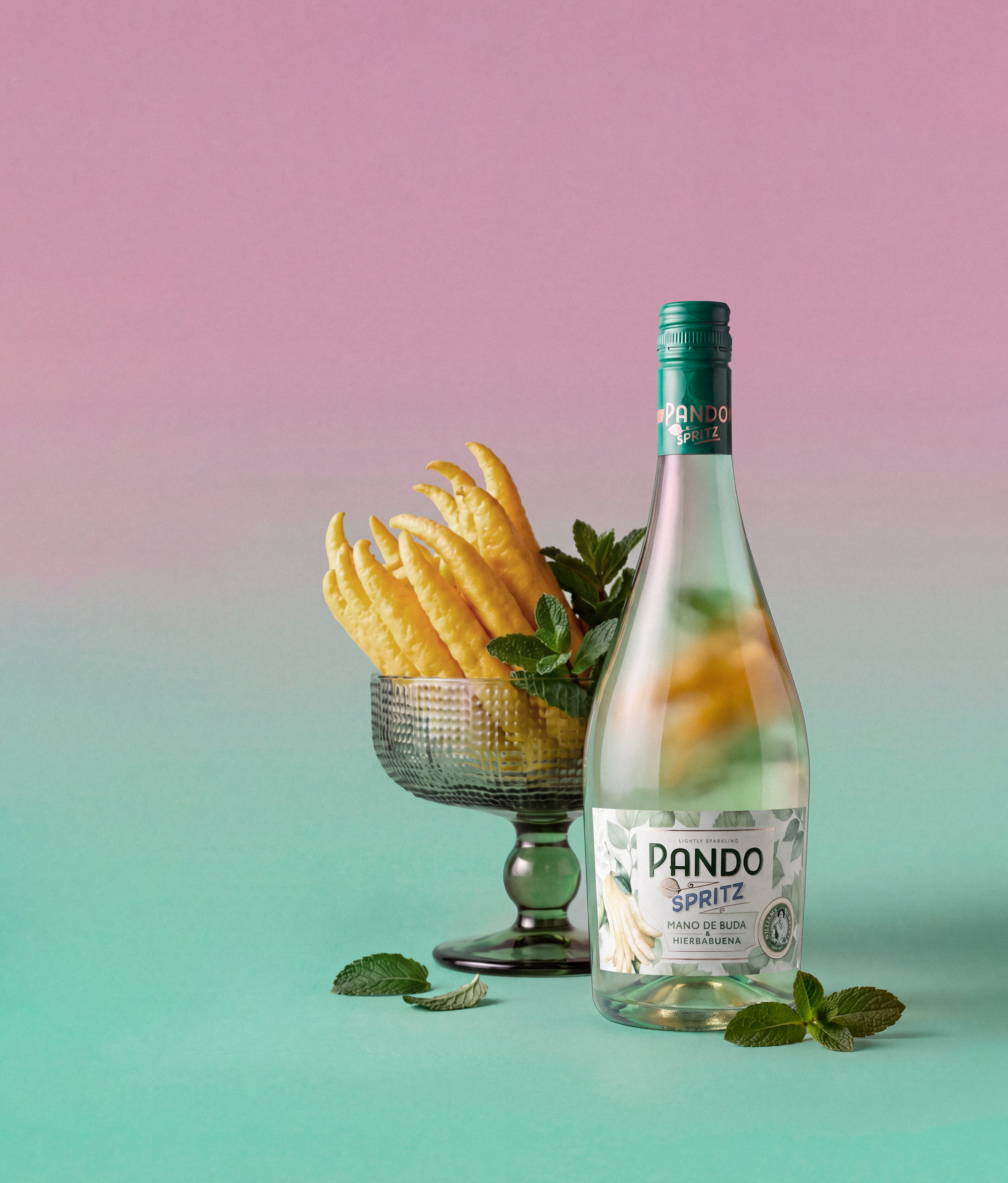 Botella de Pando Spritz junto a una copa con limón y hierbabuena